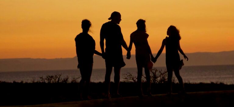Familie-silhouet bij zonsondergang symboliseert het multiculturele gezin van Fadim Kurt en haar vriend Marvin